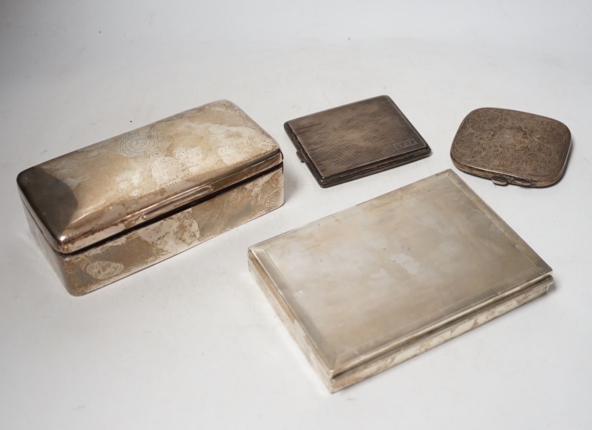 A 1930's engine turned silver cigarette box, 16.6cm, an Edwardian silver cigarette box and two silver cigarette cases.